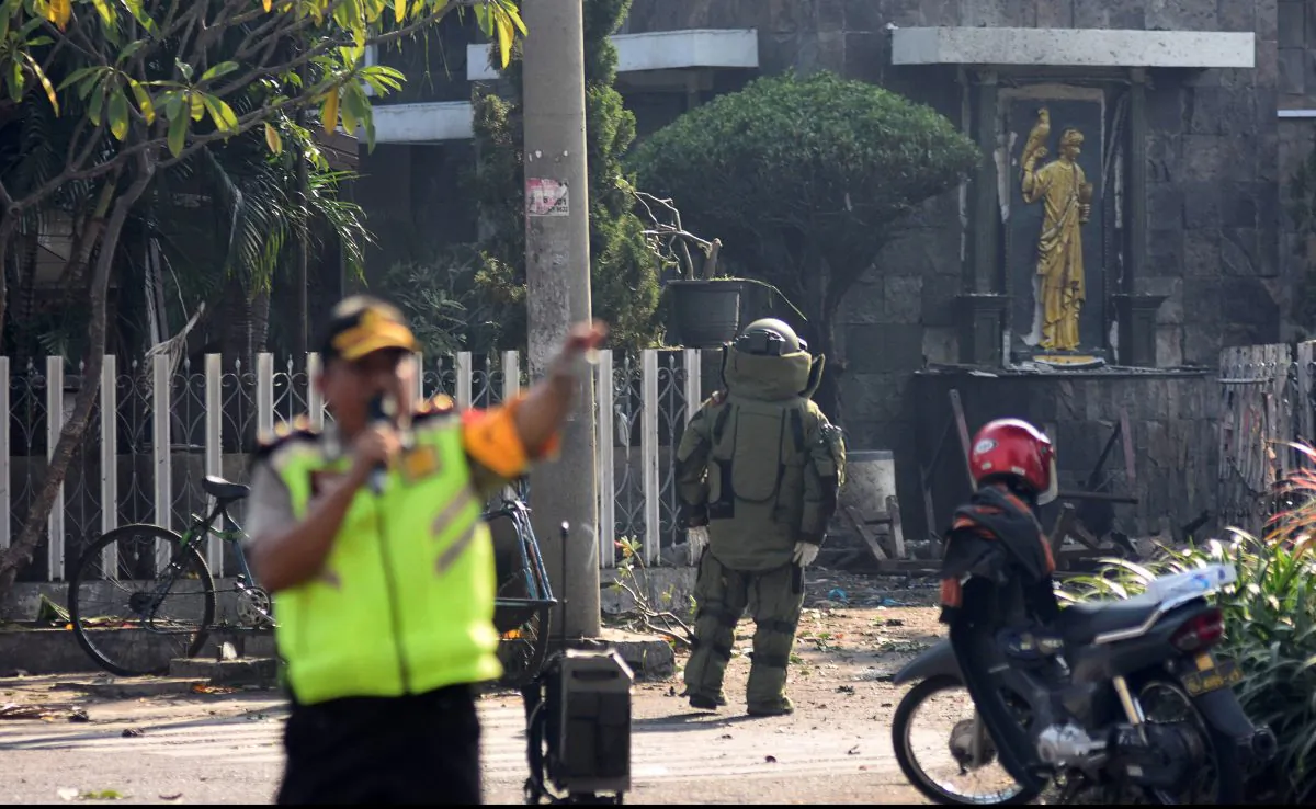 A member of the police bomb squad unit examines the site of an explosion outside the Immaculate Santa Maria Catholic Church, in Surabaya, East Java, Indonesia May 13, 2018,  in this photo taken by Antara Foto. (Antara Foto/M Risyal Hidayat / via Reuters)