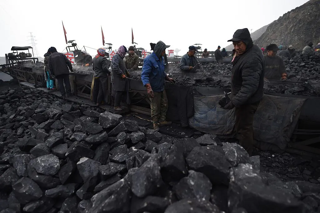 Workers sort coal on a conveyor belt near a coal mine in Datong, in China's northern Shanxi Province on Nov. 20, 2015. (Greg Baker/AFP/Getty Images)