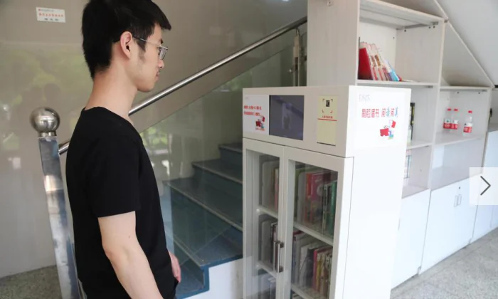 A student at Hangzhou Number 11 High School gets his face scanned before retrieving books from the classroom library, in Hangzhou City in eastern China. (Screenshot via Sina)