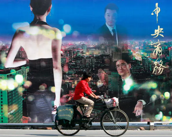 A cyclist rides past an advertisement billboard at the city's central business district of Beijing on Sept.5, 2007. (TEH ENG KOON/AFP/Getty Images)