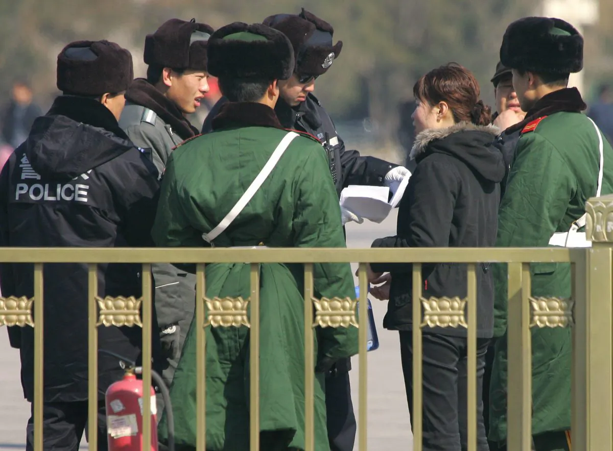 Police and paramilitary guards surround a woman while a policeman reads her petition amid tightened security on Tiananmen Square in Beijing, on March 6, 2007. (Frederic J. Brown/AFP/Getty Images)