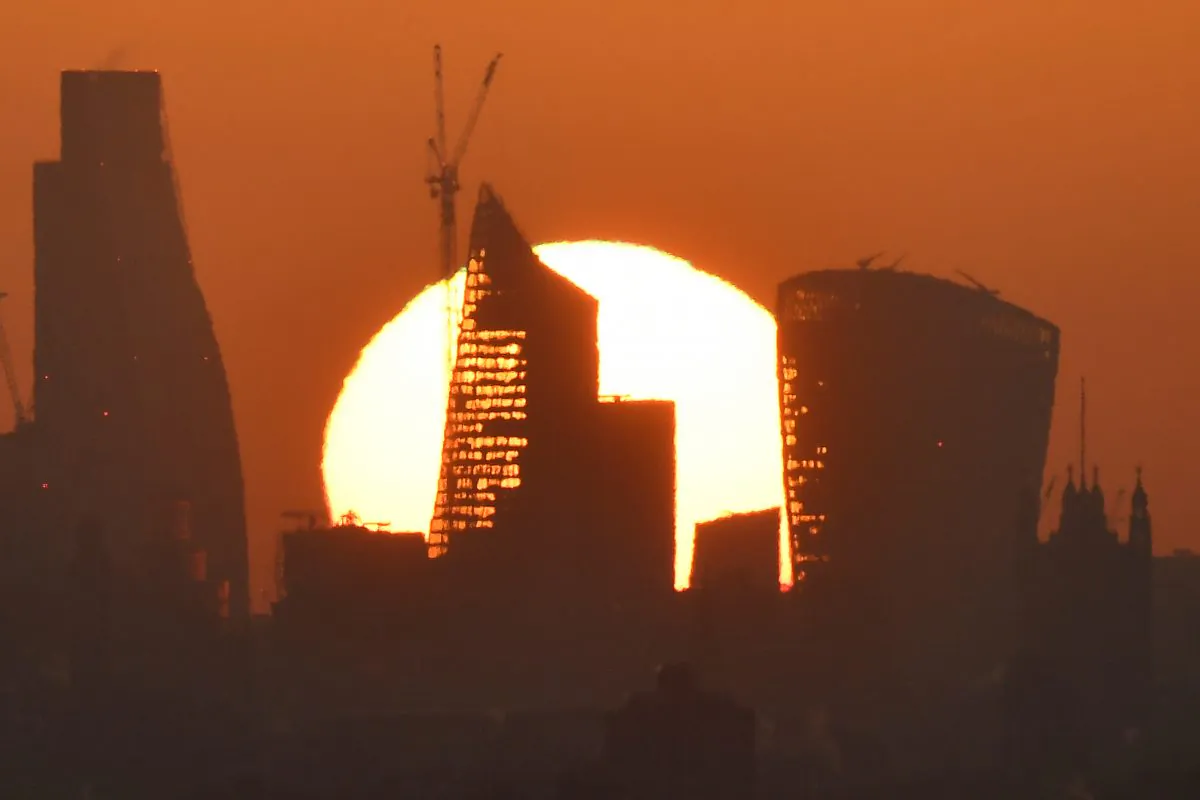 The sun is seen rising over skyscrapers in the City of London financial district in London, Britain, on May 3, 2018. (Toby Melville/Reuters)