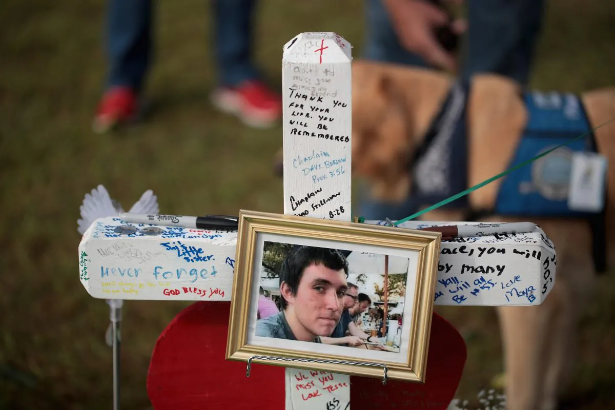 A photo of Christian Garcia hangs on a cross at a memorial in front of Santa Fe High School on May 22, 2018 in Santa Fe, Texas. The makeshift memorial honors the victims of last Friday's shooting when 17-year-old student entered the school with a shotgun and a pistol and opened fire, killing 10 people.  (Scott Olson/Getty Images)