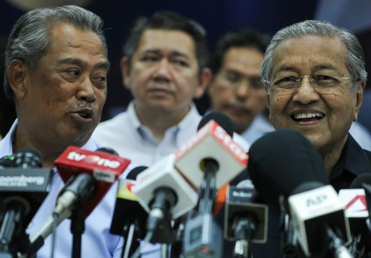 Mahathir Mohamad (R) and former Malaysian deputy prime minister Muhyiddin Yassin (L) talk to each other before a press conference with members of the opposition party in Kuala Lumpur on March 4, 2016. (MOHD RASFAN/AFP/Getty Images)
