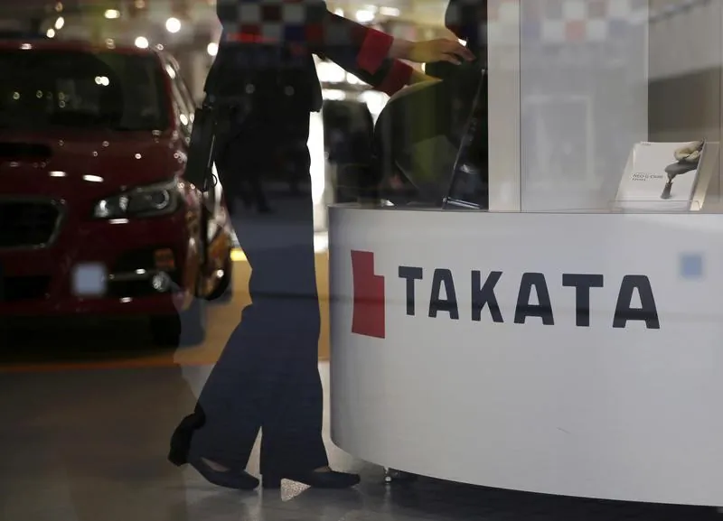 A woman stands next to a logo of Takata Corp at a showroom for vehicles in Tokyo, Japan, Nov. 6, 2015. (Reuters/Toru Hanai/File Photo)