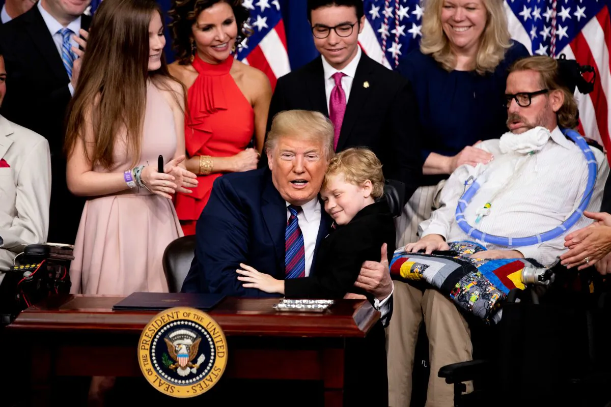 President Donald Trump hugs a boy with muscular dystrophy at the signing ceremony for the Right to Try legislation at the White House in Washington on May 30, 2018. (Samira Bouaou/Epoch Times)
