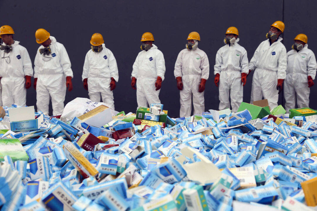 Chinese workers preparing to destroy fake medicines seized in Beijing, on March 14, 2013. Chinese companies are increasingly dominating the manufacturing of the global pharmaceutical market, a development that raises national security concerns in the United States and elsewhere. (STR/AFP/Getty Images)