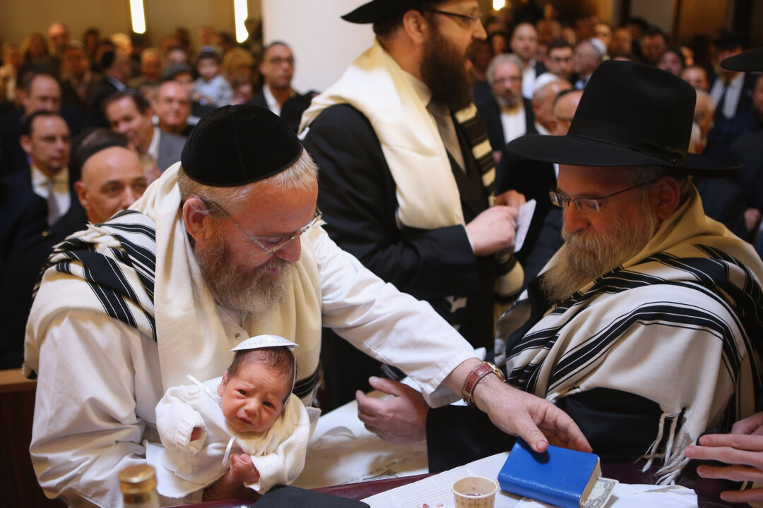 Mohel Manachem Fleischmann (L) concludes the circumcision ceremony of baby infant Mendl Teichtal at the Chabad Lubawitsch Orthodox Jewish synagogue on March 3, 2013 in Berlin, Germany. (Sean Gallup/Getty Images)