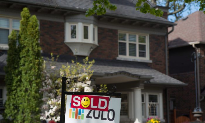 A sold sign is shown in front of a west-end Toronto home in this file photo. The housing bubbles in Vancouver and Toronto appear to be gradually deflating, but affordability is still extremely poor. (The Canadian Press/Graeme Roy)