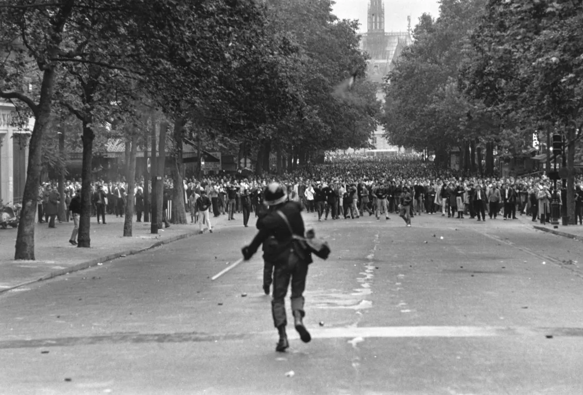 A policeman throws a tear gas canister to disperse crowds during student riots in Paris in the summer of 1968. The student protesters thought they would liberating people from consumer society, but ended up building a culture addicted to consumption (Reg Lancaster/Getty Images)