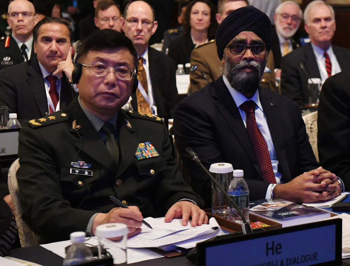 Lt. Gen. He Lei (L), vice president of the People's Liberation Army's Academy of Military Science, and Hajit Sajjan (R), Canadian National Defense Minister, attend the first plenary session of the 17th Asian Security Summit of the IISS ShangriLa Dialogue in Singapore on June 2, 2018. (Roslan Rahman/AFP/Getty Images) 