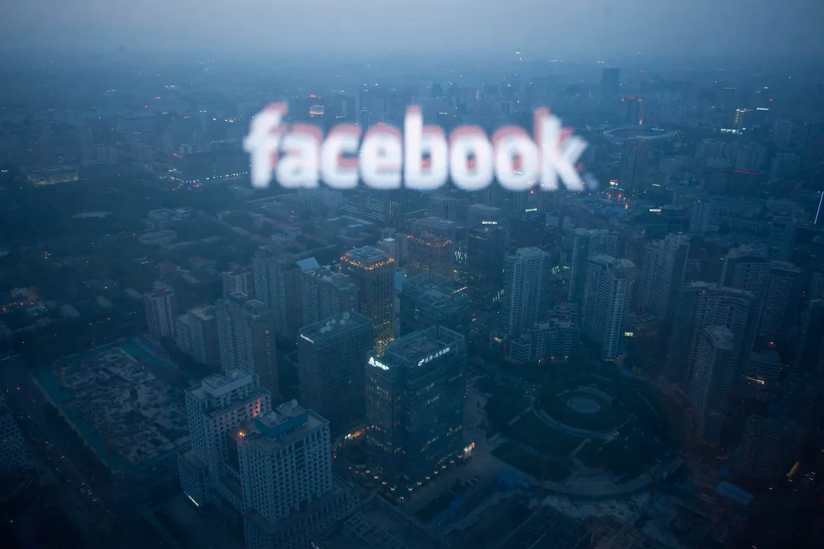 A computer screen displaying the logo of social networking site Facebook reflected in a window before the Beijing skyline on May 16, 2012. (Ed Jones/AFP/Getty Images)