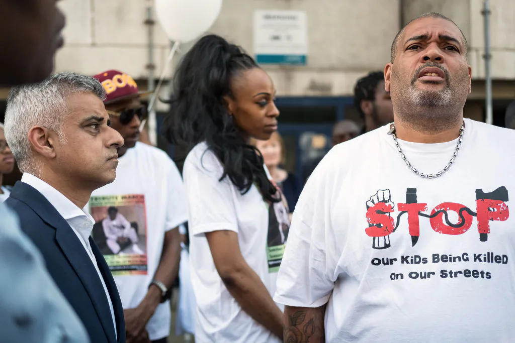 London Mayor Sadiq Khan (L) looks on as a man wears an anti-violence shirt following the murder of teenager Rhyhiem Ainsworth Barton, ahead of a solidarity march on May 8, 2018 in south London, England. The 17-year-old boy was shot during a weekend of violence in London, with two other boys shot in a separate incident less than 24 hours later. (Leon Neal/Getty Images)
