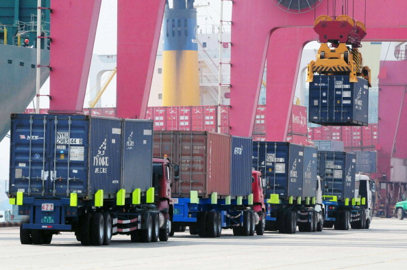 Trucks preparing to load and unload shipping containers in a port in Qingdao, in eastern China’s Shandong Province, on April 10, 2013. (STR/AFP/Getty Images)