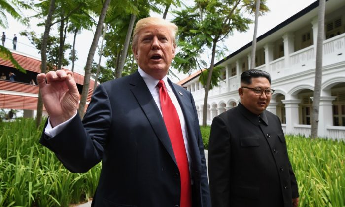 US President Donald Trump speaks to the media as he walks with North Korea's leader Kim Jong Un during a break in talks at their historic US-North Korea summit, at the Capella Hotel on Sentosa island in Singapore on June 12, 2018. (Anthony Wallace/AFP/Getty Images)