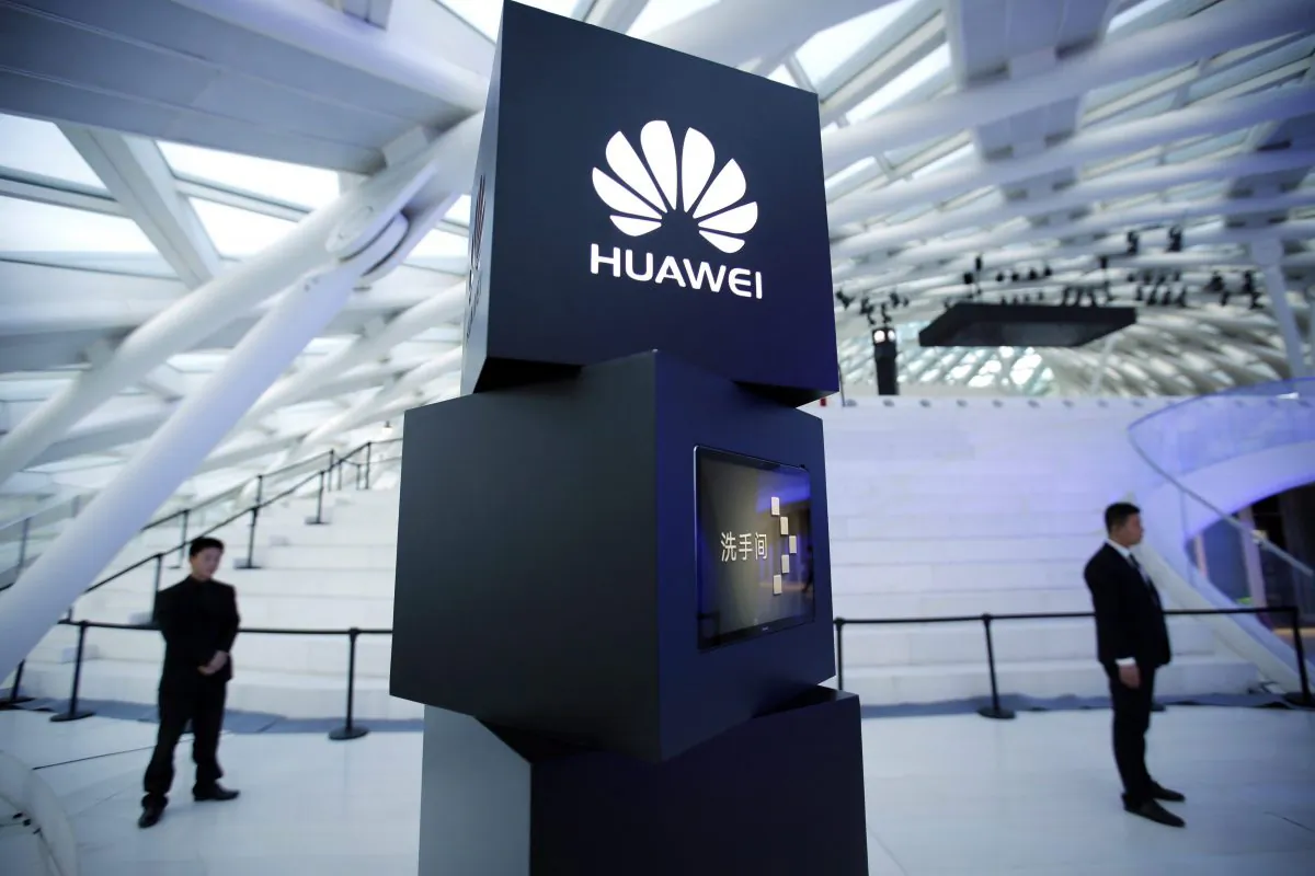 Security personnel stand near a pillar with the Huawei logo at a launch event for the Huawei MateBook in Beijing in a file photo. The Chinese telecommunications giant has established a strong presence in the Canadian market, which worries cyber security experts. (AP Photo/Mark Schiefelbein)