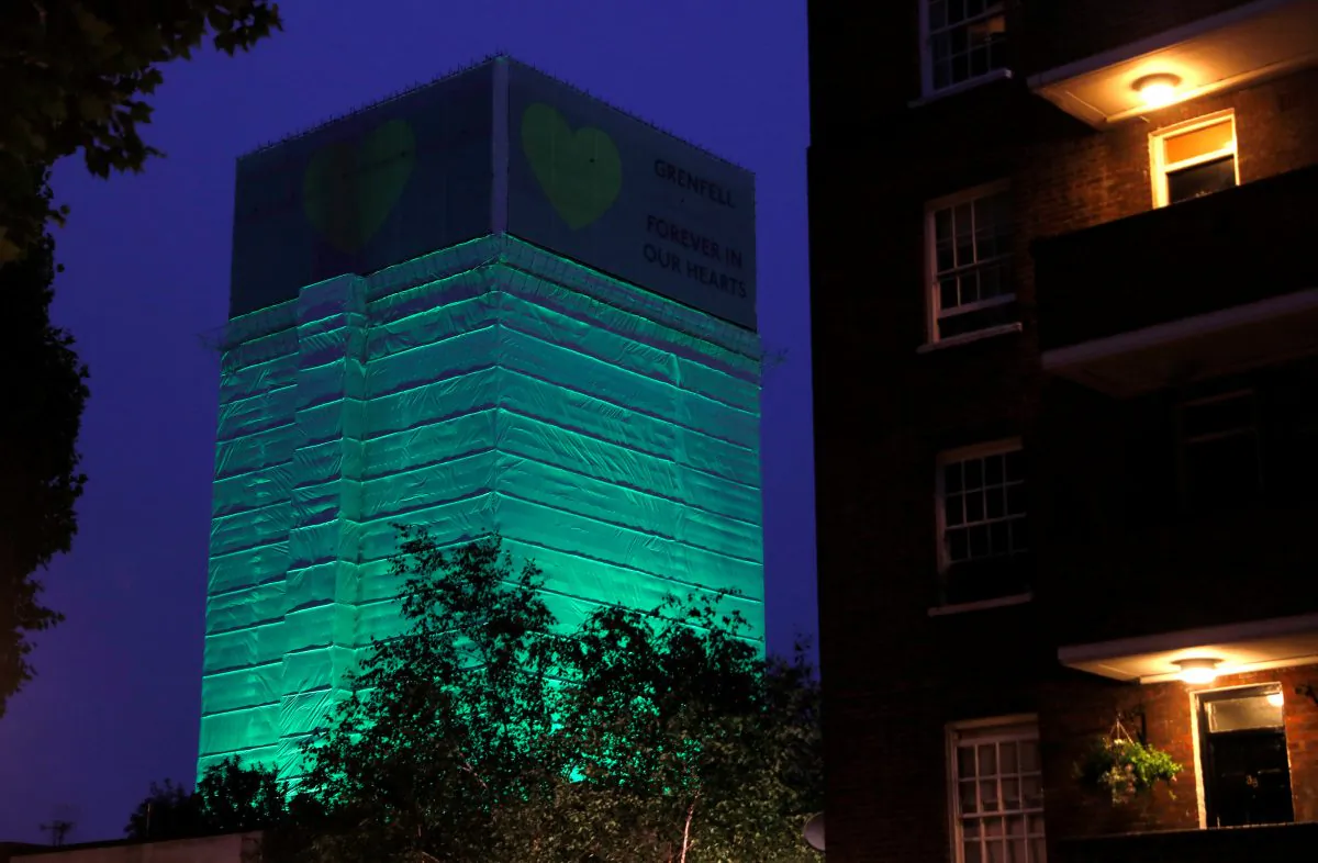 Grenfell Tower is seen covered and illuminated with green light one year after the tower fire in London on June 13, 2018. (Peter Nicholls/Reuters)