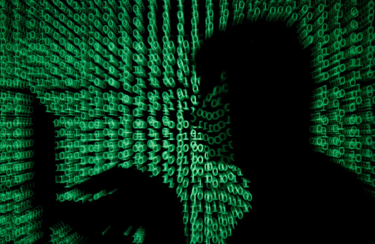 A man holds a laptop computer as cyber code is projected on him in this illustration picture taken on May 13, 2017. (Reuters/Kacper Pempel/File Photo)