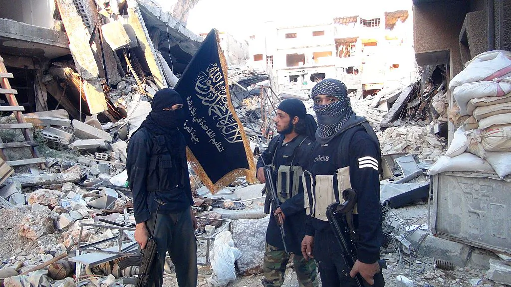 Terrorists from the al-Qaeda group in the Levant, Al-Nusra Front, stand among destroyed buildings near the front line with Syrian government soldiers in a Yarmuk Palestinian refugee camp south of Damascus on Sept. 22, 2014. (Rami Al-Sayed/AFP/Getty Images)