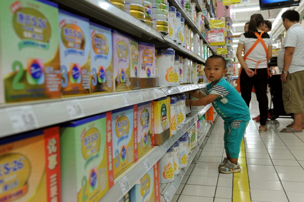 A baby plays around in the imported baby products section while his parents talk to a sales clerk in a supermarket in Beijing in 2013. (STR/AFP/Getty Images)