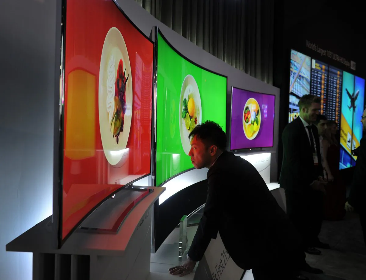 An attendee takes a close look at LG's 105-inch OLED TV at the 2014 International Consumer Electronics Show in Las Vegas, Nevada, on Jan. 8, 2014. (Robyn Beck/AFP/Getty Images)