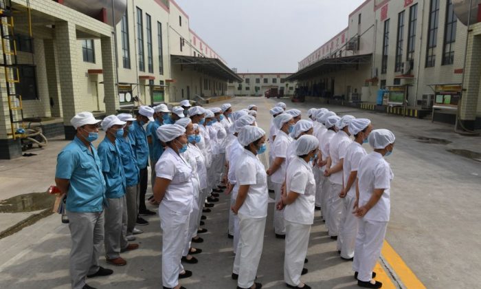 Workers line up to sing communist “red” songs at an instant noodle factory in Henan Province on Sept. 29, 2017. (Greg Baker/AFP/Getty Images)