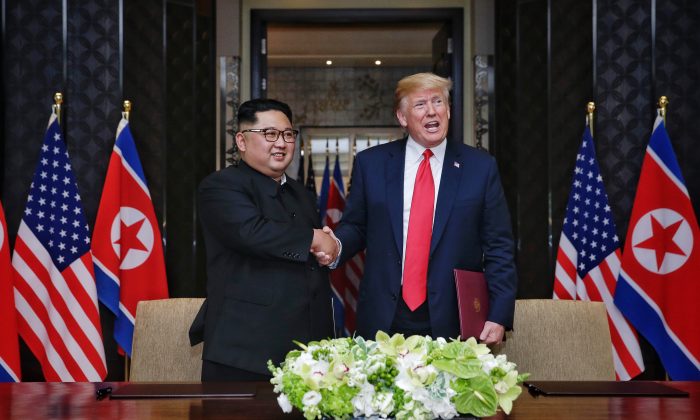 In this handout photograph provided by The Strait Times, North Korean leader Kim Jong-un (L) with U.S. President Donald Trump (R) during their historic U.S.-DPRK summit at the Capella Hotel on Sentosa island on June 12, 2018 in Singapore. (Kevin Lim/The Strait Times/Handout/Getty Images)