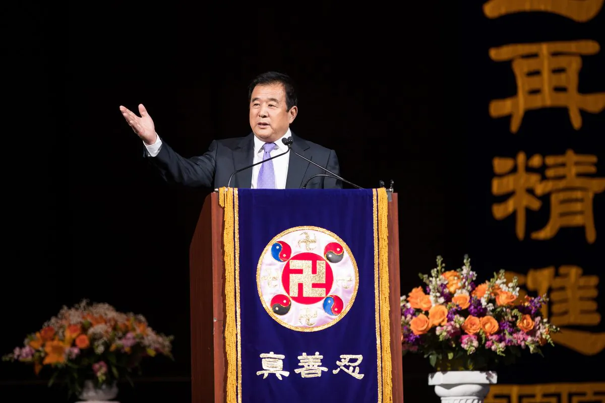 Mr. Li Hongzhi, the founder of Falun Gong, addresses more than 9,000 practitioners of the spiritual discipline at the Capital One Arena in Washington on June 21, 2018. On the podium is the falun, the emblem of Falun Gong, which has at its center the srivatsa, an ancient Buddhist symbol. (Edward Dye/Epoch Times)