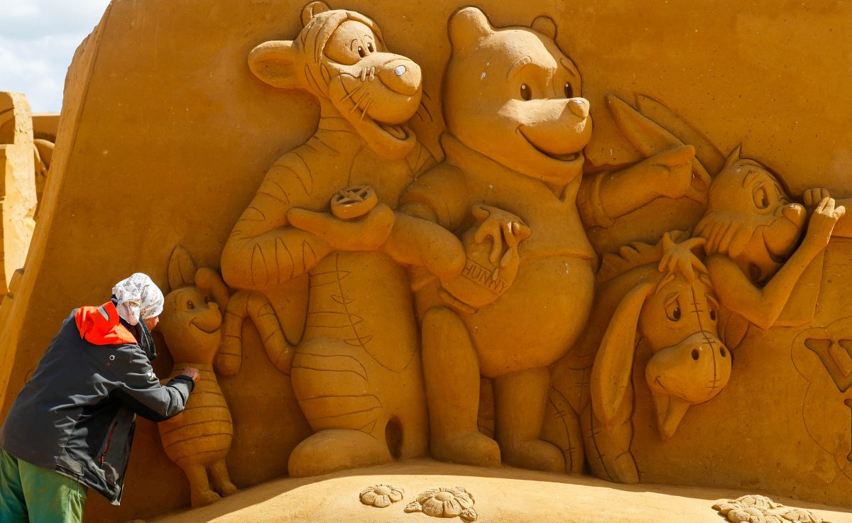 A sand carver works on a sculpture during the Sand Sculpture Festival "Disney Sand Magic" in Ostend, Belgium, on June 21. (REUTERS/Yves Herman)