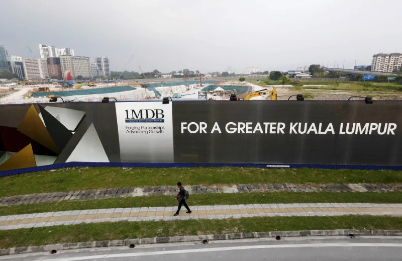 A man walks past a 1 Malaysia Development Berhad (1MDB) billboard at the funds flagship Tun Razak Exchange development in Kuala Lumpur, March 1, 2015. (Reuters/Olivia Harris/File Photo)