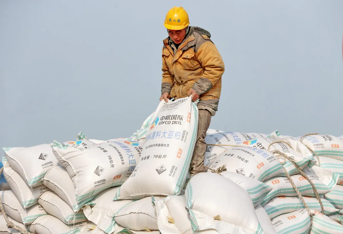 A Chinese worker carries a bag of soybean meal at a port in Nantong, Jiangsu Province, China on March 22, 2018. (AFP/Getty Images)