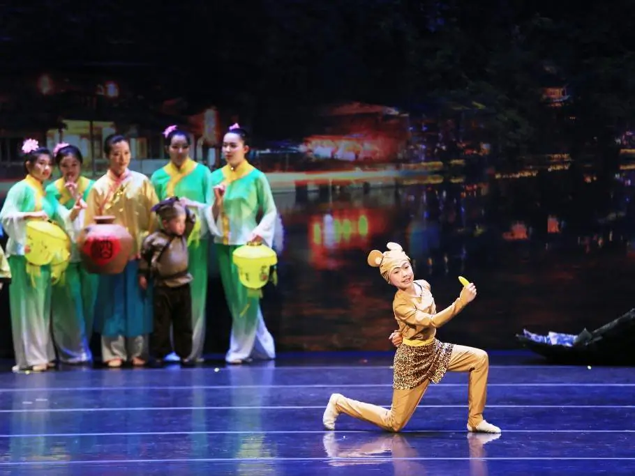 In Act One of Xian Yun’s year-end production, the young Monkey King, played by 11-year-old Alyssa Li, is born from a rock while people celebrate a festival. (Courtesy of Xunqing Li/Xian Yun Academy)