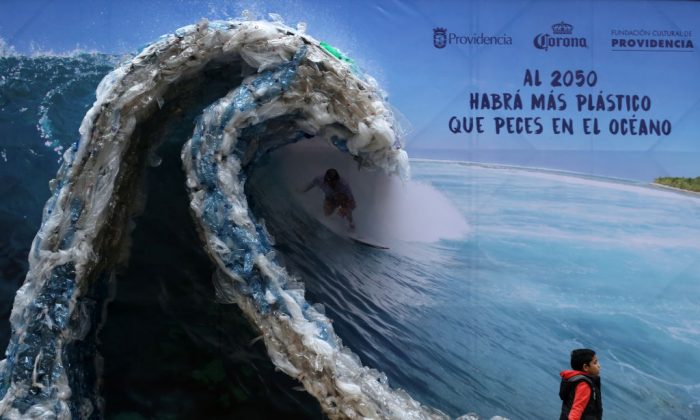 TOPSHOT - A billboard portraiting a man, surfing a wave made out of plastic bags and bottles, to denounce ocean's pollution is pictured in Santiago on the eve of the World Environment Day, on June 4, 2018.     (Photo credit should read CLAUDIO REYES/AFP/Getty Images)