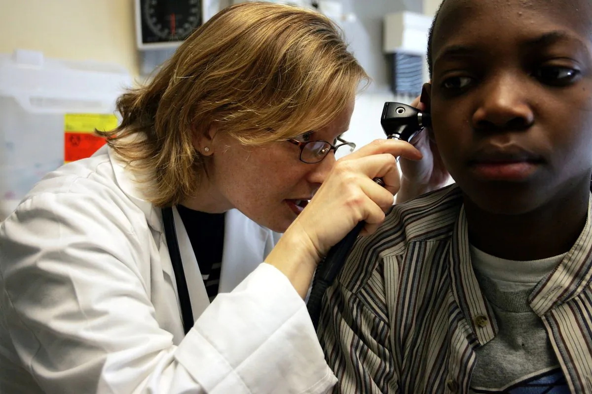 A doctor looks through a otoscope during an examination of patient at the Codman Square Health Center in Dorchester, Mass. on April 11, 2006. (Joe Raedle/Getty Images)