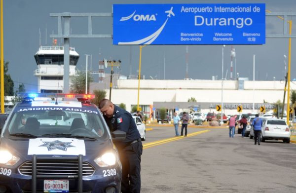 A policeman stands guard at the airport of Durango, in northern Mexico, after a plane carrying 97 passengers and four crew crashed during take off on July 31, 2018. (Lulu Murillo/AFP/Getty Images)