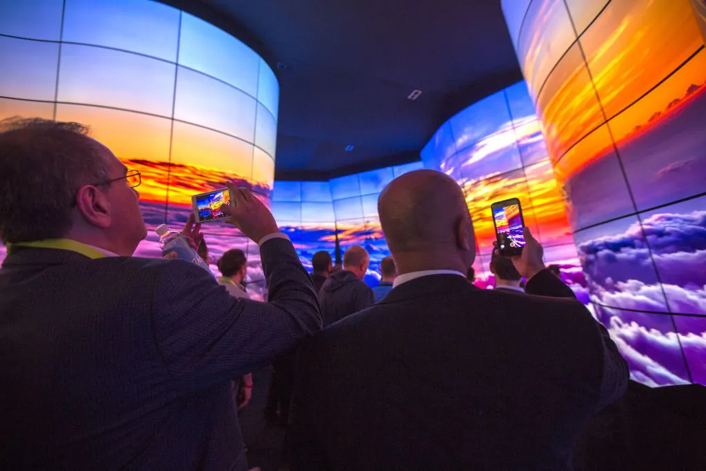 People walk through a display of LG OLED televisions at CES in Las Vegas, Nevada, on January 9, 2018. (David McNew/AFP/Getty Images)
