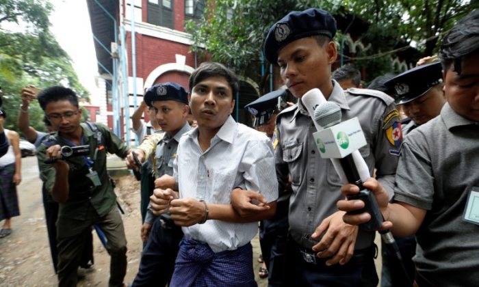 Detained Reuters journalist Kyaw Soe Oo is escorted by police while leaving Insein court in Yangon, Myanmar July 2, 2018. (Reuters/Ann Wang)
