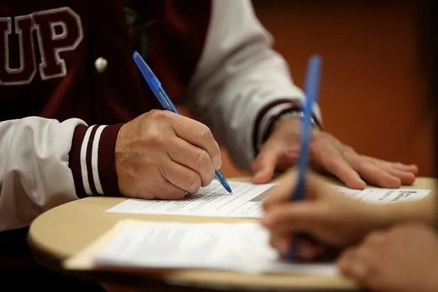 People sign employment forms in a file photo. (Justin Sullivan/Getty Images)