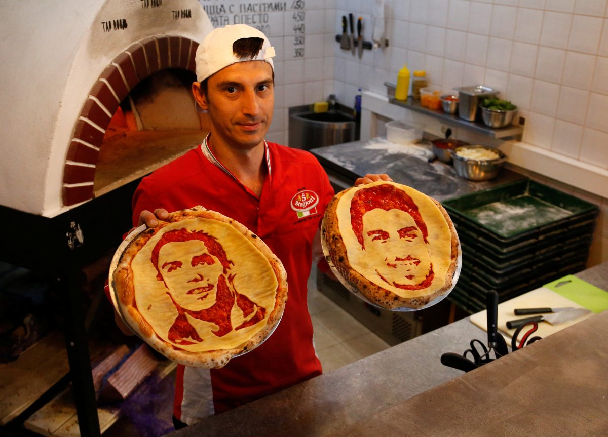 Chef Valery Maksimchik poses with pizzas decorated with portraits of Portugal's Cristiano Ronaldo and Uruguay's Luis Suarez at HopHead Tap Room in St. Petersburg, Russia, on June 29. (REUTERS/Anton Vaganov)