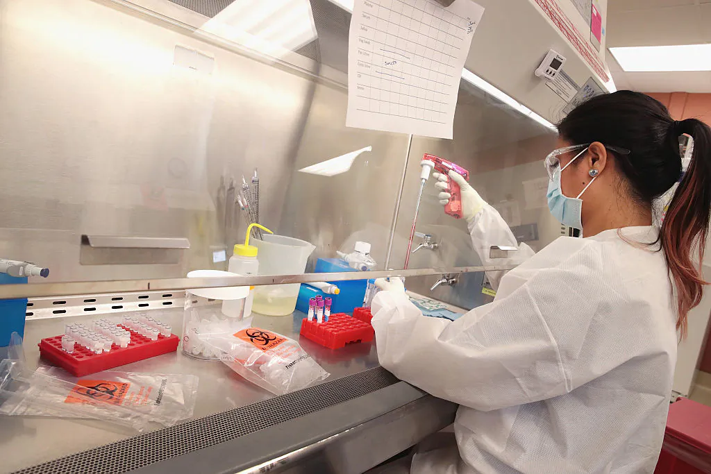 Mariel Mohns, a research specialist at the AIDS Vaccine Research Labs at the University of Wisconsin-Madison, processes body fluids taken from pregnant rhesus macaque monkeys infected with the Zika virus in Madison, Wisconsin on June 28, 2016 (Scott Olson/Getty Images)