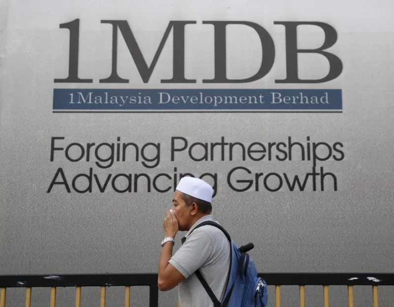 A man walks past a billboard for 1 Malaysia Development Berhad (1MDB), a state investment fund, at its flagship Tun Razak Exchange development in Kuala Lumpur, Malaysia, on Feb. 27, 2015. (Olivia Harris/Reuters)