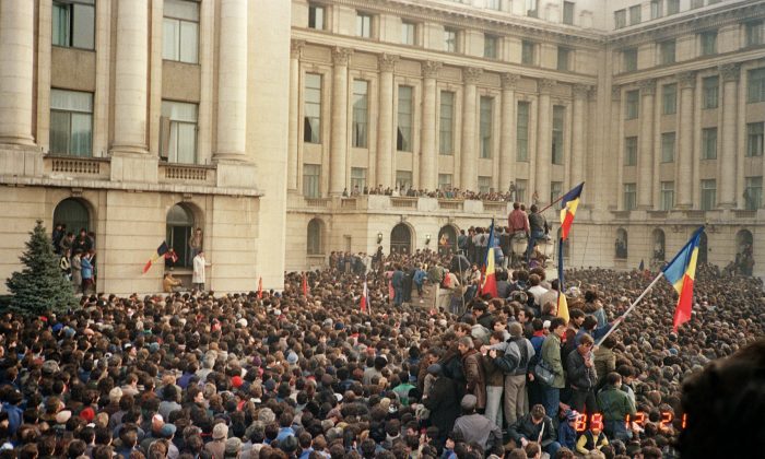 Bucharest citizens wave Romanian flags as they stage an anti-communist demonstration at the Republic Square on Dec. 21, 1989, shortly before the fall of the communist regime. (Photo credit should read AFP/Getty Images)