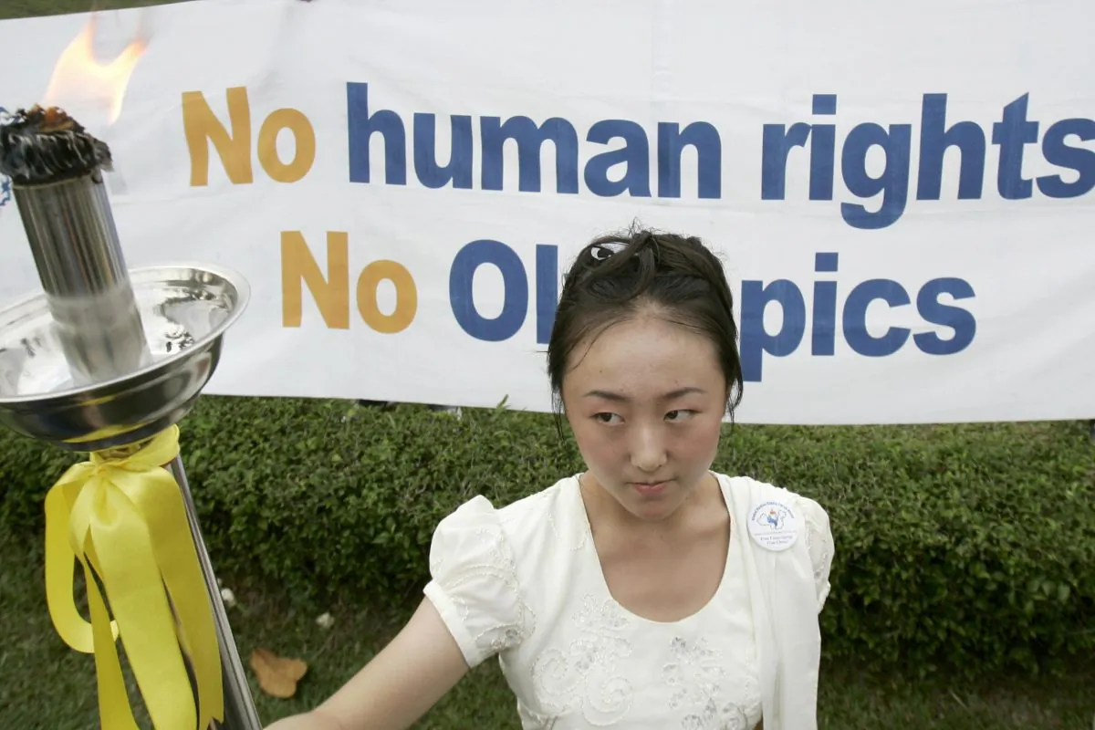 A female activist holds up a torch, its flame a symbol for universal human rights, during an "alternative" torch relay highlighting China's human rights record in Kuala Lumpur on May 25, 2008. The Human Rights Torch Relay, which protests China's hosting of the 2008 Olympic Games, highlighted the Chinese government's handling of the Tibet riots, the persecution of Falun Gong practitioners, and its ties with the Myanmar military junta, organizers said. (TENGKU BAHAR/AFP/Getty Images)