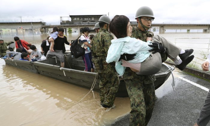 Residents are rescued from a flooded area by Japan Self-Defense Force soldiers in Kurashiki, southern Japan, in this photo taken by Kyodo July 7, 2018. (Kyodo/Reuters)
