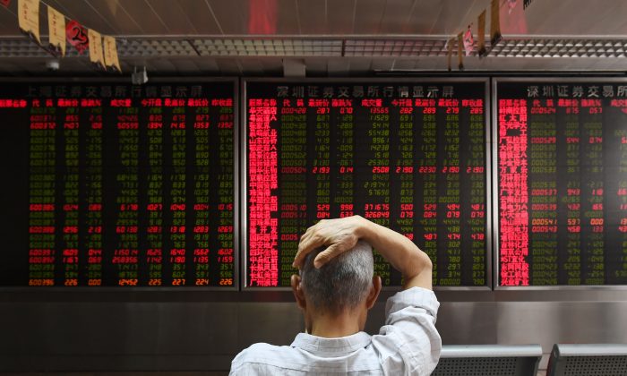 A man checks stock price movements at a securities company in Beijing on July 4, 2018. (Greg Baker/AFP/Getty Images)