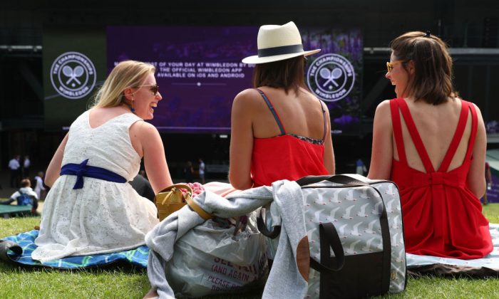 Tennis fans sit on Murray Mound above the big screen in the grounds of Wimbledon All England Tennis Clubs in London, on July 4, 2018. (Matthew Lewis/Getty Images)