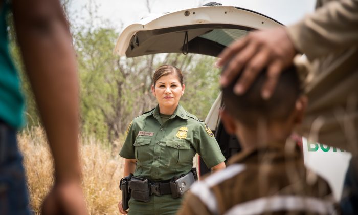 Border Patrol agent Marlene Castro speaks to a group of illegal immigrants and children who just crossed into the United States from Mexico, in Hidalgo County, Texas, on May 26, 2017. (Benjamin Chasteen/The Epoch Times)
