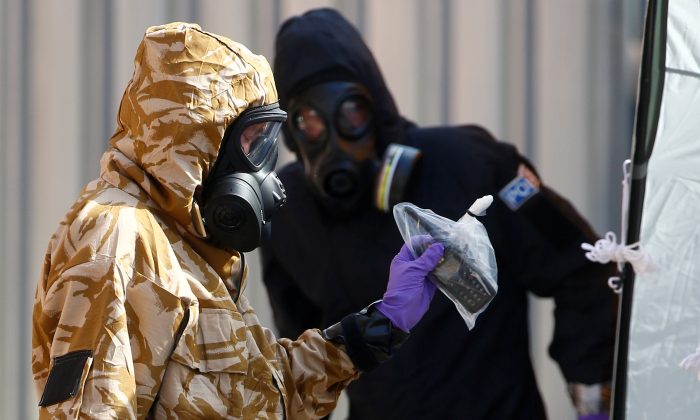 Forensic investigators wearing protective suits emerge from the rear of John Baker House in Amesbury, United Kingdom, on July 6, 2018. (Reuters/Henry Nicholls/File Photo)