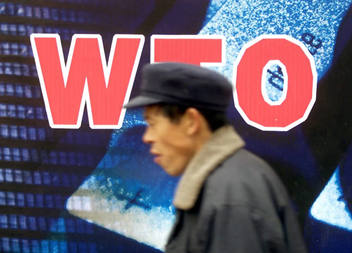 A Chinese man walks past a billboard promoting the country's membership to the World Trade Organization (WTO), in Beijing, on Dec. 10, 2001. (Goh Chai Hin/AFP/Getty Images)