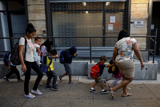 Children cover their faces as they are escorted to the Cayuga Center, which provides foster care and other services to immigrant children separated from their families, in New York City on July 10, 2018. (Reuters/Brendan McDermid)